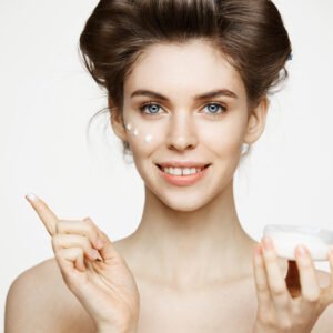 Professional woman applying anti-aging cream containing Hydroxypropyl Tetrahydropyrantriol.